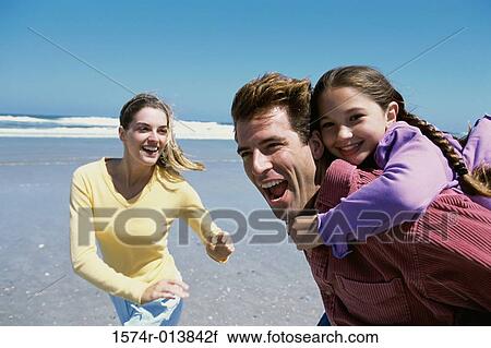 Parents playing with their daughter on the beach View Large Photo Image Stock Image - Parents playing with their daughter on the beach. Fotosearch