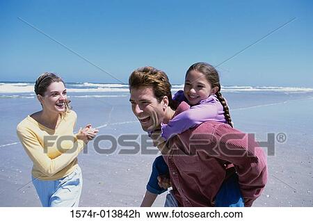 Parents playing with their daughter on the beach View Large Photo Image Stock Image - Parents playing with their daughter on the beach. Fotosearch