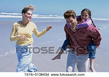 Parents playing with their daughter on the beach View Large Photo Image Stock Image - Parents playing with their daughter on the beach. Fotosearch