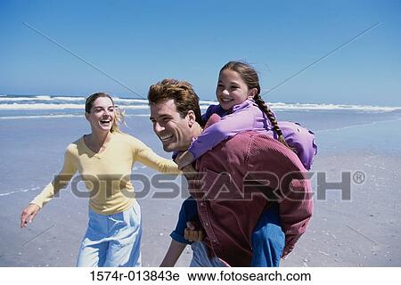 Parents playing with their daughter on the beach View Large Photo Image Stock Image - Parents playing with their daughter on the beach. Fotosearch
