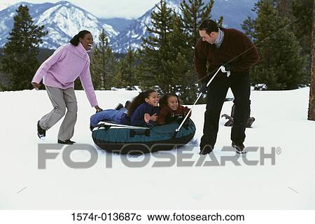 Parents pulling an inflatable tube with their two daughters View Large Photo Image Stock Image - Parents pulling an inflatable tube with their two daughters. Fotosearch