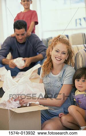 Stock Image - Parents unpacking a cardboard box. Fotosearch