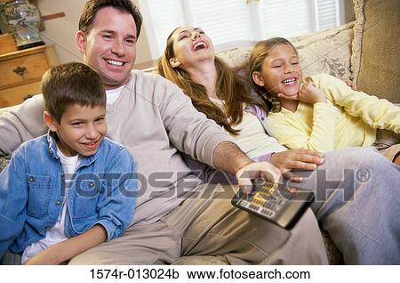 Stock Image - Parents watching television with their son and daughter. Fotosearch