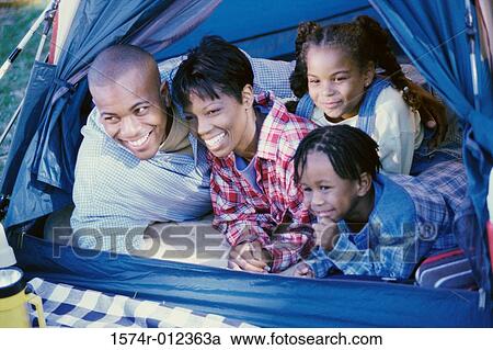 Parents with their children smiling in a tent View Large Photo Image Stock Image - Parents with their children smiling in a tent. Fotosearch