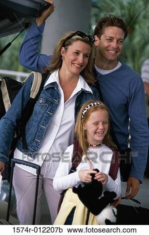 Stock Image - Parents with their daughter and their luggage. Fotosearch