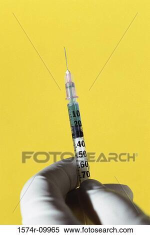 Person holding a syringe View Large Photo Image Stock Photography - Person holding a syringe. Fotosearch