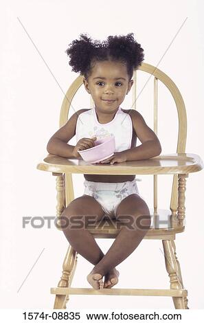 Portrait of a baby girl sitting in a high chair holding a bowl View Large Photo Image Stock Photography - Portrait of a baby girl sitting in a high chair holding a bowl. Fotosearch