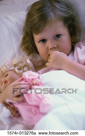 Portrait of a baby girl with a doll lying in bed View Large Photo Image Stock Image - Portrait of a baby girl with a doll lying in bed. Fotosearch