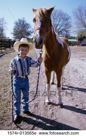 Portrait of a boy holding the reins of a horse View Large Photo Image Stock Image - Portrait of a boy holding the reins of a horse. Fotosearch
