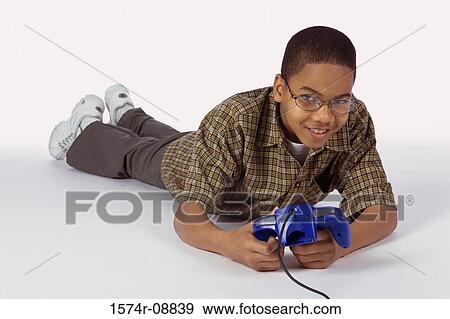 Portrait of a boy lying on the floor holding a game joystick View Large Photo Image Stock Photo - Portrait of a boy lying on the floor holding a game joystick. Fotosearch