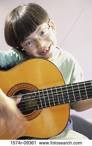 Portrait of a boy playing a guitar View Large Photo Image Stock Image - Portrait of a boy playing a guitar. Fotosearch