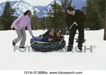 Stock Image - Portrait of a brother and sister with their parents skiing. Fotosearch