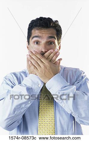 Stock Image - Portrait of a businessman covering his mouth. Fotosearch
