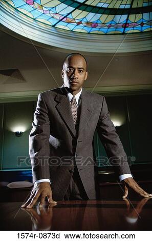 Portrait of a businessman leaning against a table View Large Photo Image Stock Image - Portrait of a businessman leaning against a table. Fotosearch