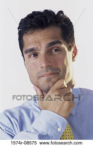 Stock Photography - Portrait of a businessman with his hand on his chin. Fotosearch