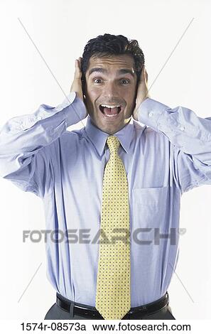 Stock Image - Portrait of a businessman with his hands covering his ears. Fotosearch
