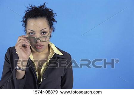 Stock Photo - Portrait of a businesswoman adjusting her eyeglasses. Fotosearch