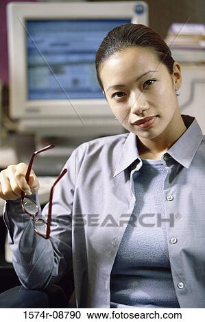 Portrait of a businesswoman sitting in an office holding her eyeglasses View Large Photo Image Stock Image - Portrait of a businesswoman sitting in an office holding her eyeglasses. Fotosearch