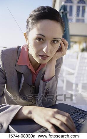 Portrait of a businesswoman sitting in front of a laptop View Large Photo Image Stock Image - Portrait of a businesswoman sitting in front of a laptop. Fotosearch