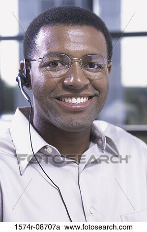 Portrait of a customer service representative wearing a headset smiling View Large Photo Image Stock Image - Portrait of a customer service representative wearing a headset smiling. Fotosearch