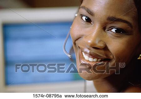 Stock Image - Portrait of a customer service representative wearing a headset smiling. Fotosearch