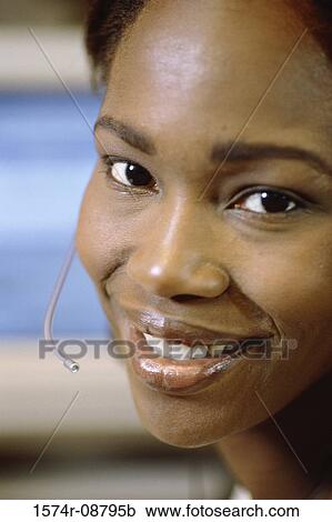 Stock Image - Portrait of a customer service representative wearing a headset smiling. Fotosearch