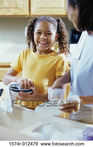 Portrait of a daughter drying dishes with her mother in the kitchen View Large Photo Image Stock Photo - Portrait of a daughter drying dishes with her mother in the kitchen. Fotosearch