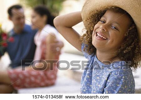 Portrait of a daughter smiling with her parents sitting behind her View Large Photo Image Stock Image - Portrait of a daughter smiling with her parents sitting behind her. Fotosearch