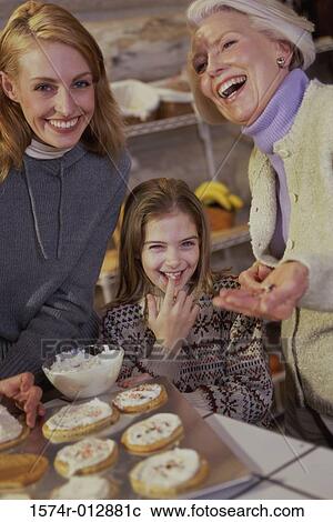 Portrait of a daughter tasting cookies being prepared by her mother and grandmother View Large Photo Image Stock Image - Portrait of a daughter tasting cookies being prepared by her mother and grandmother. Fotosearch
