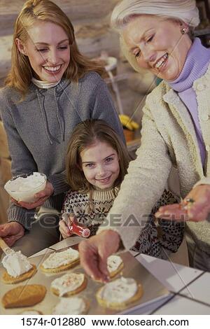 Portrait of a daughter with her mother and grandmother preparing cookies View Large Photo Image Stock Image - Portrait of a daughter with her mother and grandmother preparing cookies. Fotosearch
