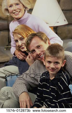 Stock Image - Portrait of a family sitting in a living room. Fotosearch