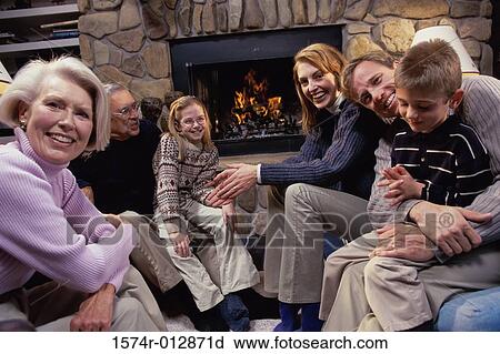 Portrait of a family sitting near the fireplace in a living room View Large Photo Image Stock Image - Portrait of a family sitting near the fireplace in a living room. Fotosearch