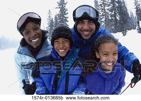 Stock Image - Portrait of a family standing together in the snow. Fotosearch