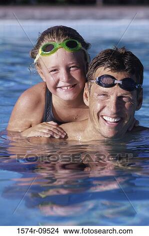 Portrait of a father and his daughter in a swimming pool View Large Photo Image Picture - Portrait of a father and his daughter in a swimming pool. Fotosearch