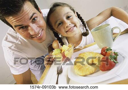 Portrait of a father and his daughter holding a breakfast tray View Large Photo Image Stock Image - Portrait of a father and his daughter holding a breakfast tray. Fotosearch