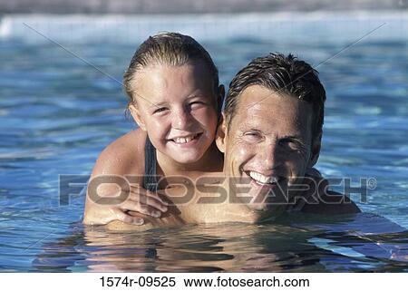 Stock Photography - Portrait of a father and his daughter in a swimming pool. Fotosearch