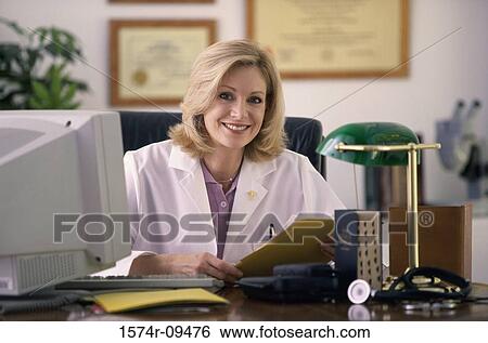 Portrait of a female doctor sitting behind a desk View Large Photo Image Stock Photograph - Portrait of a female doctor sitting behind a desk. Fotosearch