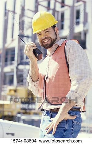 Portrait of a foreman talking on a walkie-talkie View Large Photo Image Picture - Portrait of a foreman talking on a walkie-talkie. Fotosearch