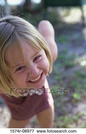 Stock Photo - Portrait of a girl bending forward smiling. Fotosearch