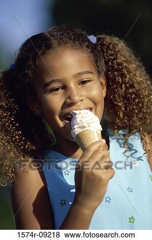 Stock Photo - Portrait of a girl eating an ice cream. Fotosearch