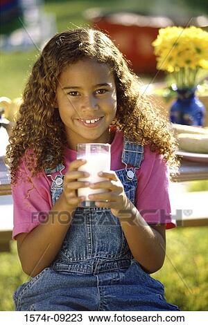 Stock Image - Portrait of a girl holding a glass of milk. Fotosearch