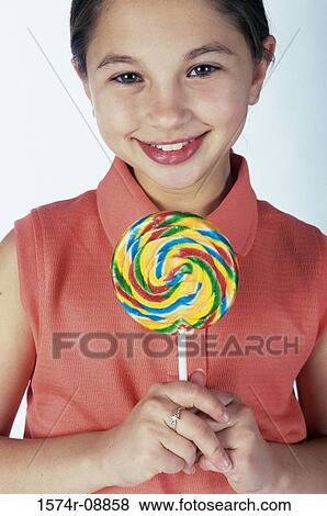 Portrait of a girl holding a lollipop View Large Photo Image Stock Photo - Portrait of a girl holding a lollipop. Fotosearch