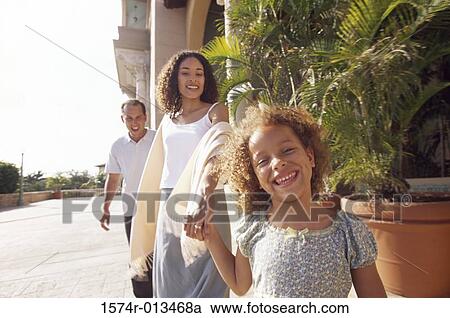 Portrait of a girl holding her mother's hand with her father walking behind them View Large Photo Image Stock Image - Portrait of a girl holding her mother's hand with her father walking behind them. Fotosearch