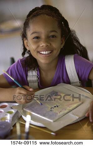 Stock Photography - Portrait of a girl painting with watercolor paints. Fotosearch