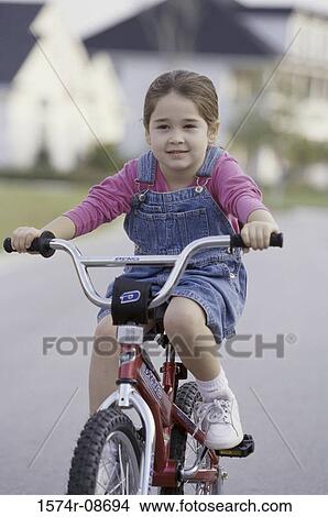 Portrait of a girl riding a bicycle View Large Photo Image Picture - Portrait of a girl riding a bicycle. Fotosearch