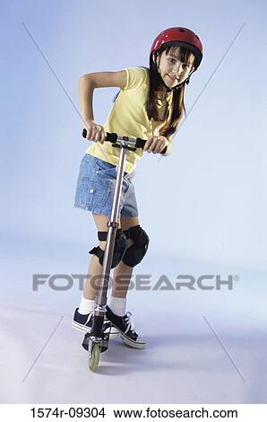 Portrait of a girl riding a push scooter View Large Photo Image Picture - Portrait of a girl riding a push scooter. Fotosearch