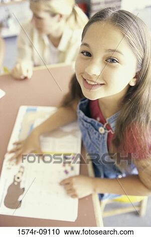 Portrait of a girl seated at a desk in a classroom View Large Photo Image Stock Image - Portrait of a girl seated at a desk in a classroom. Fotosearch