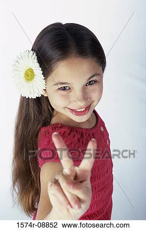 Stock Image - Portrait of a girl showing victory sign. Fotosearch