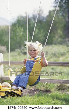 Portrait of a girl sitting on a swing View Large Photo Image Stock Image - Portrait of a girl sitting on a swing. Fotosearch