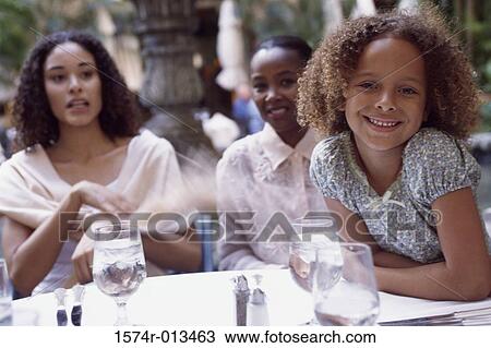 Portrait of a girl smiling with her grandmother and mother sitting behind her View Large Photo Image Stock Image - Portrait of a girl smiling with her grandmother and mother sitting behind her. Fotosearch